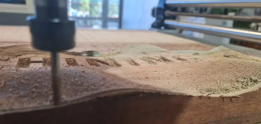 The CNC router cutting a hardwood slab in the workshop