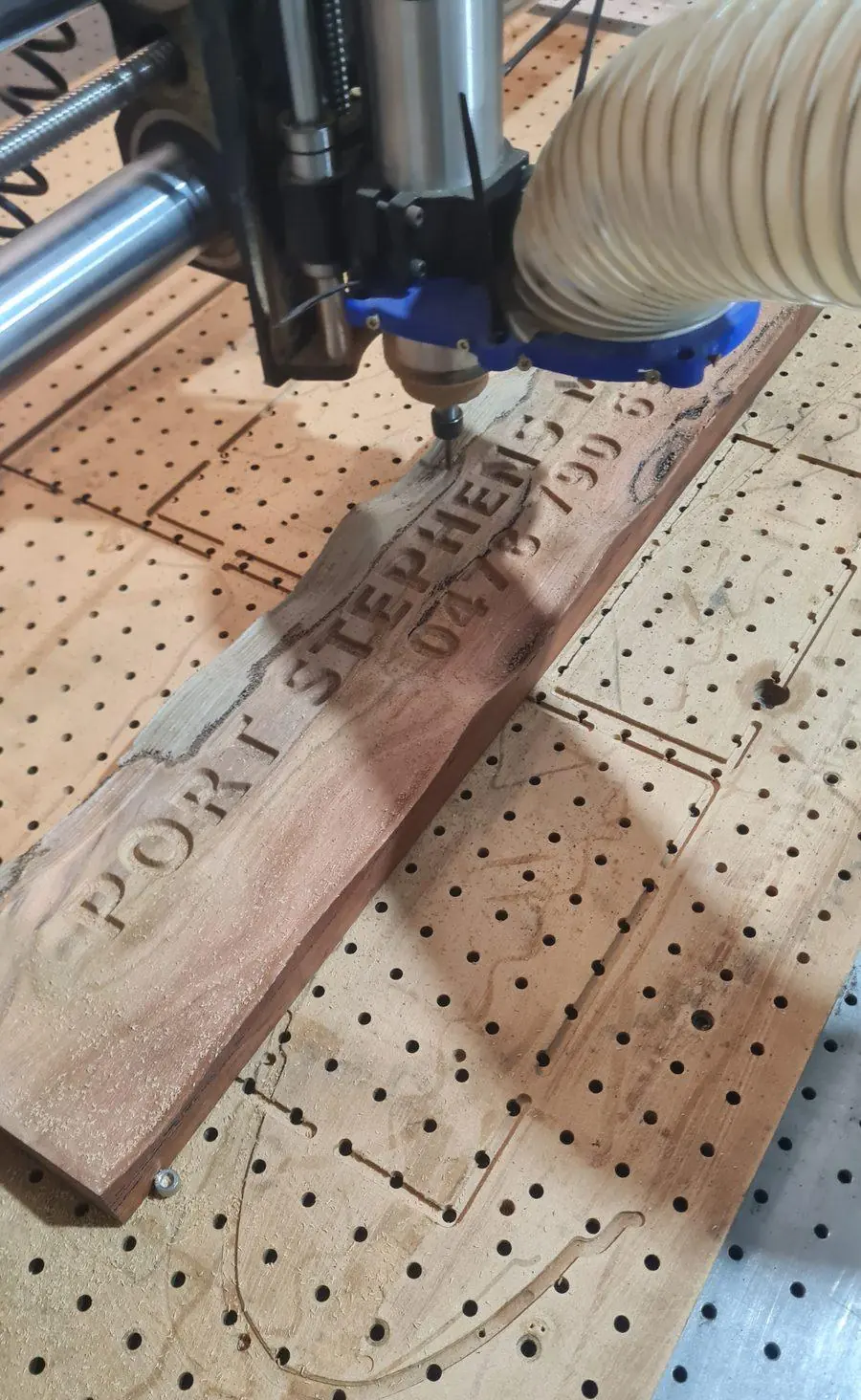 A reclaimed hardwood board clamped on the router bed